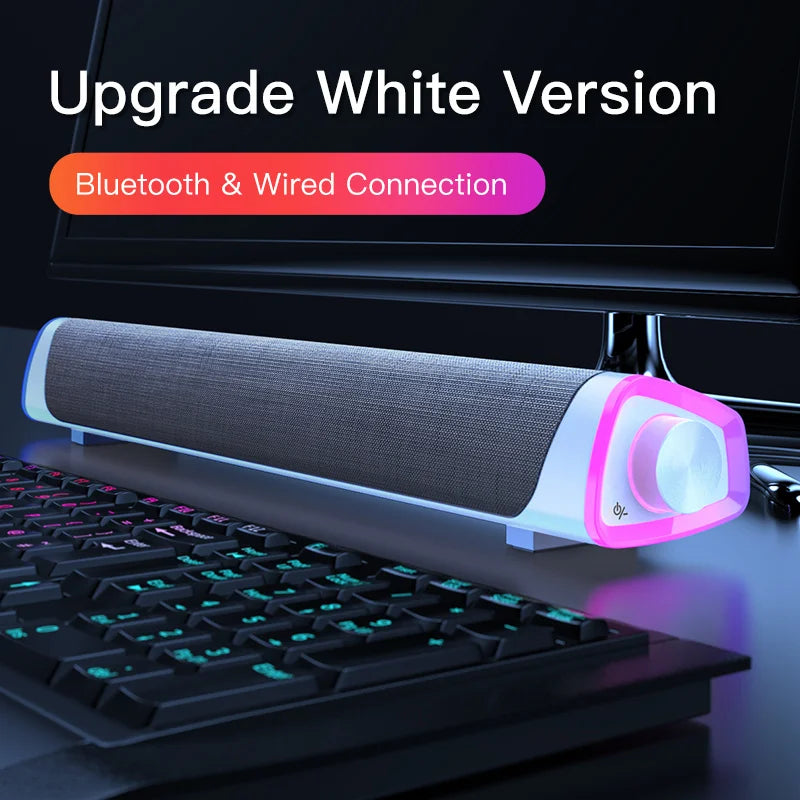 Computer speaker bar and keyboard on a desk, featuring text about upgrade options.